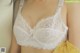 A close up of a woman wearing a white bra.