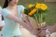 A woman holding a bunch of sunflowers in her hands.