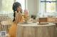 A woman sitting at a table with a stuffed animal.