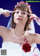 A woman in a wedding dress with blood on her face.