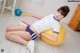 A woman sitting on an exercise ball with a hula hoop.