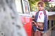 A woman standing in front of a red truck.