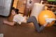 A woman laying on the floor with an exercise ball.